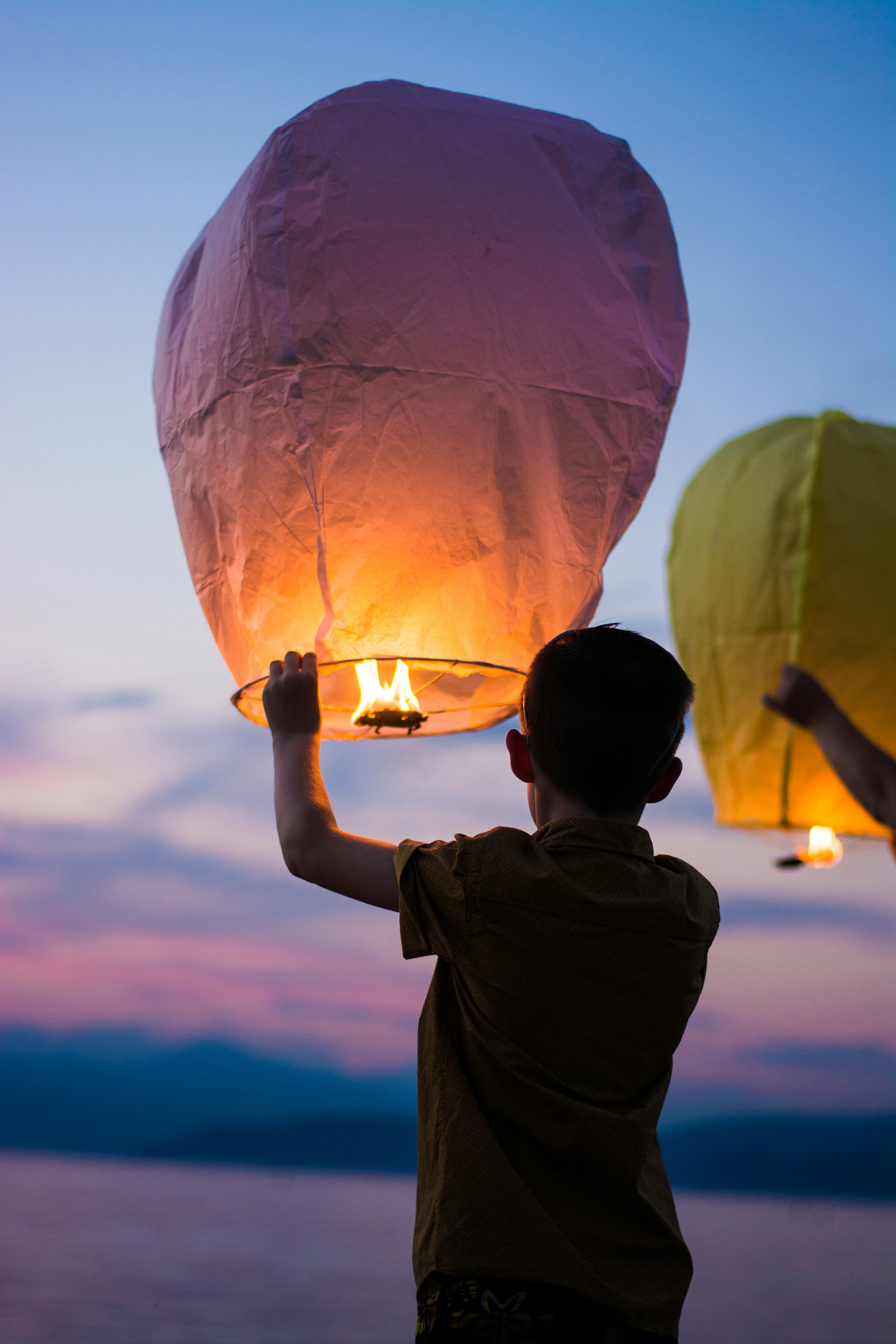 person holding yellow flammable balloon